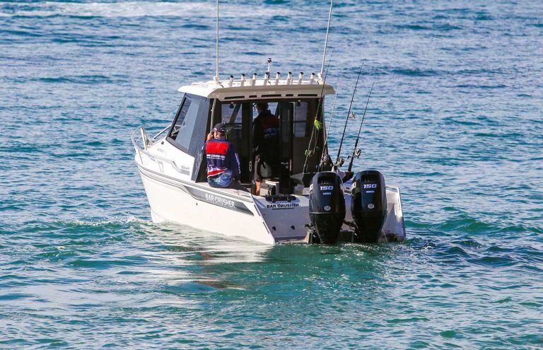 One man sitting on the edge of an HT Series boat while another drives